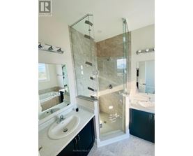 A bathroom with a glass shower door and a marble countertop.