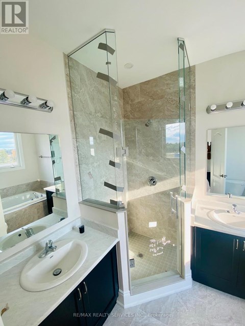 A bathroom with a glass shower door and a marble countertop.