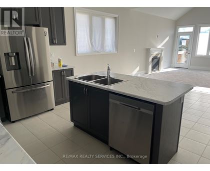 A kitchen with a sink and refrigerator in a house.