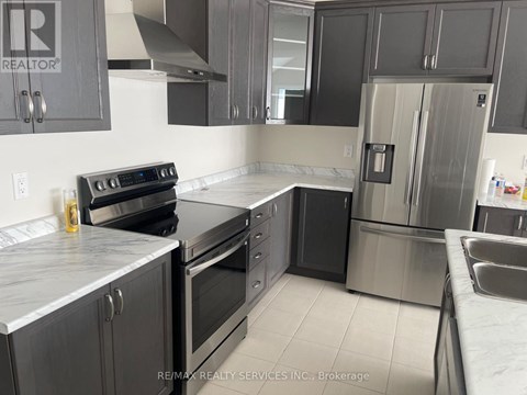 A kitchen with a stove, oven, and refrigerator.