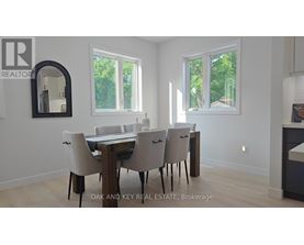 A dining room with a table and chairs.