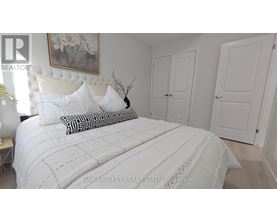 A bedroom with a large bed and a painting on the wall.