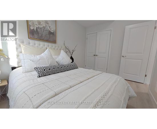 A bedroom with a large bed and a painting on the wall.