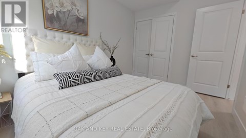 A bedroom with a large bed and a painting on the wall.