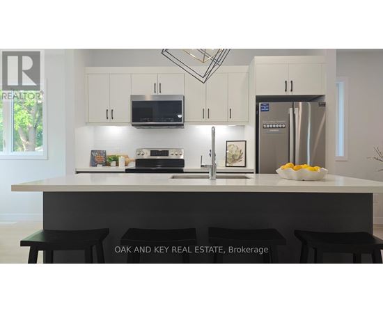 A kitchen with white cabinets and a black countertop.