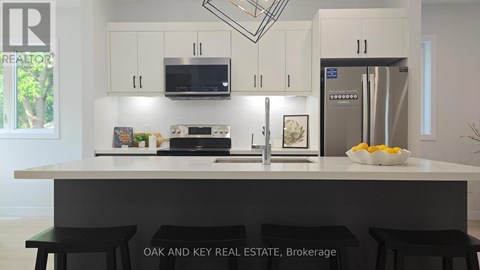 A kitchen with white cabinets and a black countertop.
