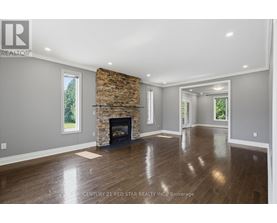 A spacious living room with a fireplace and hardwood floors.