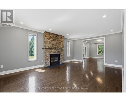 A spacious living room with a fireplace and hardwood floors.