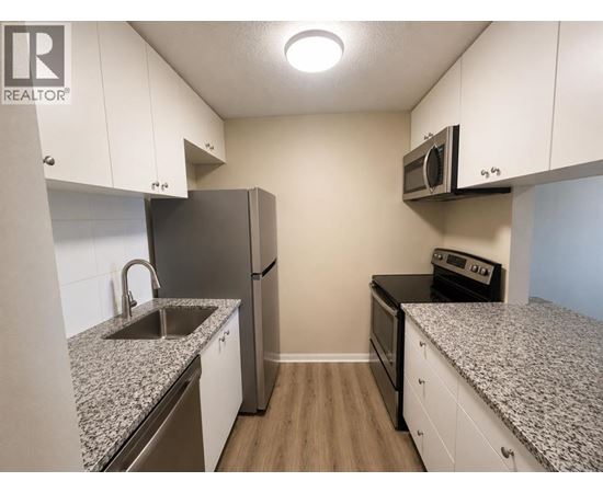 A kitchen with granite countertops and stainless steel appliances.