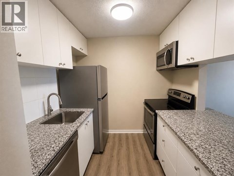 A kitchen with granite countertops and stainless steel appliances.