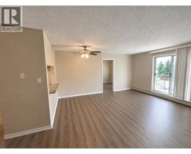 A spacious room with a ceiling fan and sliding glass doors.