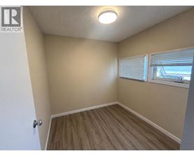 A room with a door, window, and wooden flooring.
