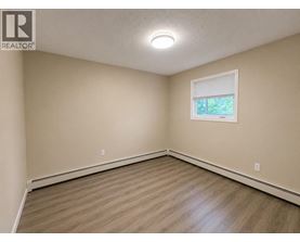 A room with a window and wooden flooring.