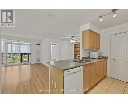 A kitchen with wooden cabinets and a white dishwasher.