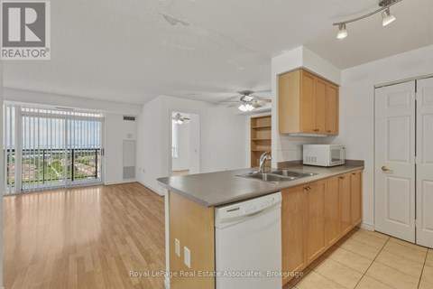 A kitchen with wooden cabinets and a white dishwasher.