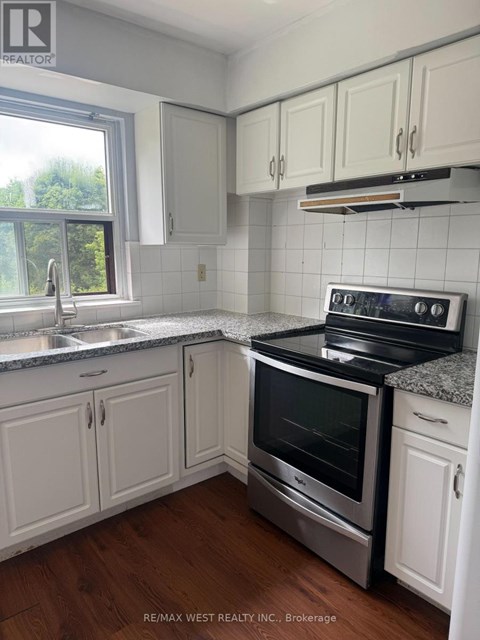 A kitchen with white cabinets and a stove top oven.