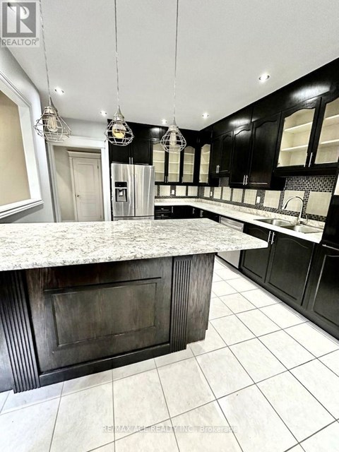 A kitchen with a marble countertop and black cabinets.