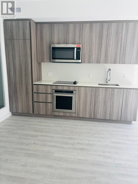 A modern kitchen with a microwave and oven built into the cabinetry.
