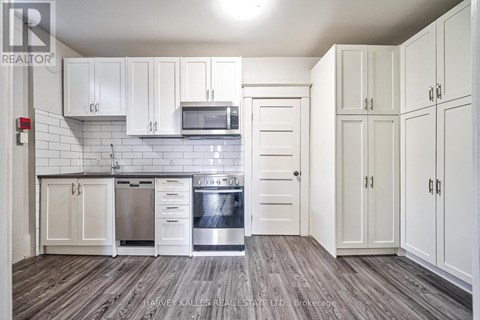 A kitchen with white cabinets and a stainless steel dishwasher.