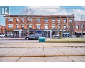 A street view of a building with a car parked in front.