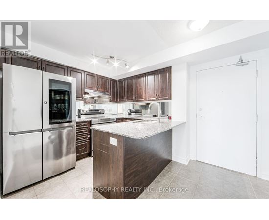 A modern kitchen with a stainless steel refrigerator and wooden cabinets.