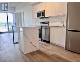 A kitchen with a marble island and stainless steel appliances.