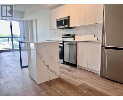 A kitchen with a marble island and stainless steel appliances.
