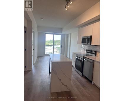 A modern kitchen with a marble island and stainless steel appliances.