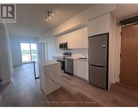 A kitchen with white cabinets and a marble island.