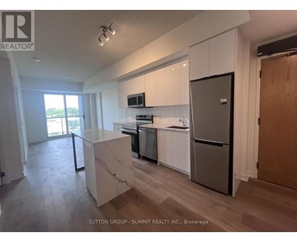 A kitchen with white cabinets and a marble island.