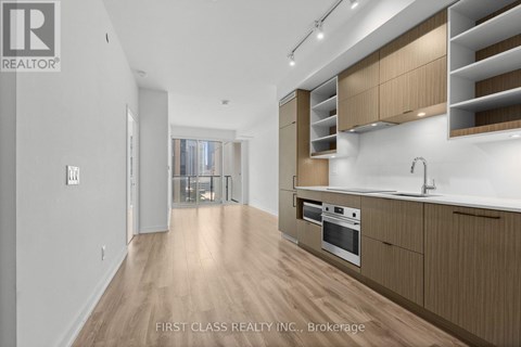 A modern kitchen with wooden cabinets and a stainless steel oven.