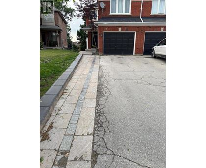 A white car is parked in front of a black garage door.
