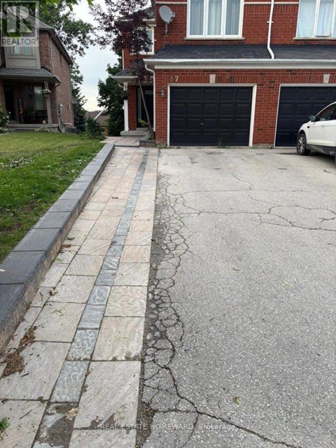 A white car is parked in front of a black garage door.