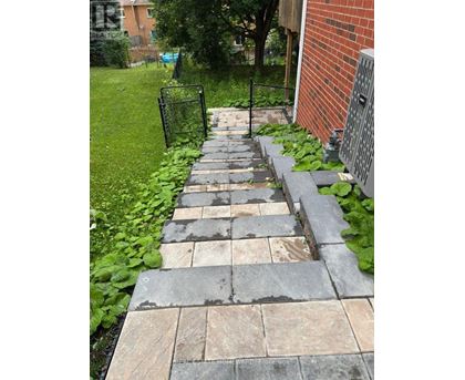 A stone pathway leads to a brick building.