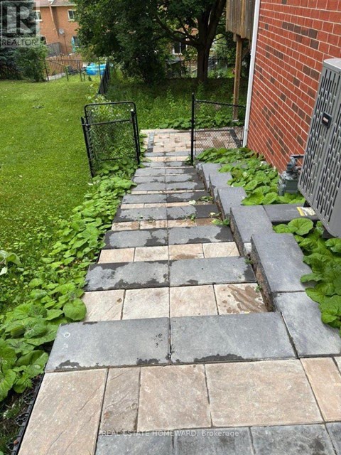 A stone pathway leads to a brick building.
