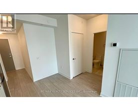 A room with a white door and a toilet in the corner.