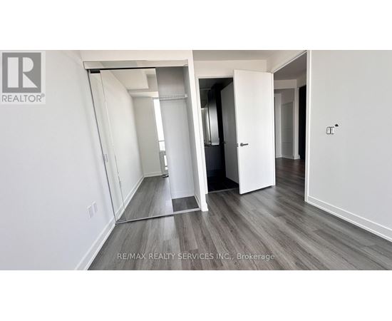 A room with a white wall and a wooden floor.