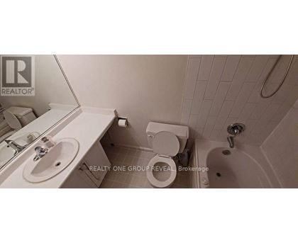A white bathroom with a toilet, sink, and bathtub.