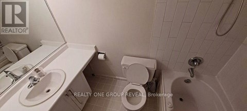 A white bathroom with a toilet, sink, and bathtub.