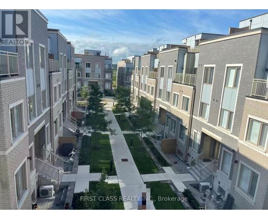 A view of a residential area with apartment buildings and a green lawn in the foreground.