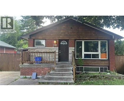 A small brown house with a black door and a small porch.