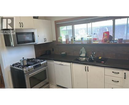 A kitchen with a stove, oven, microwave, and cabinets.