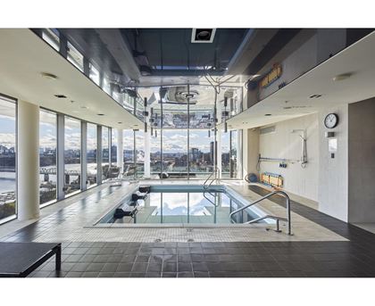 A large indoor swimming pool with a view of the outdoors.