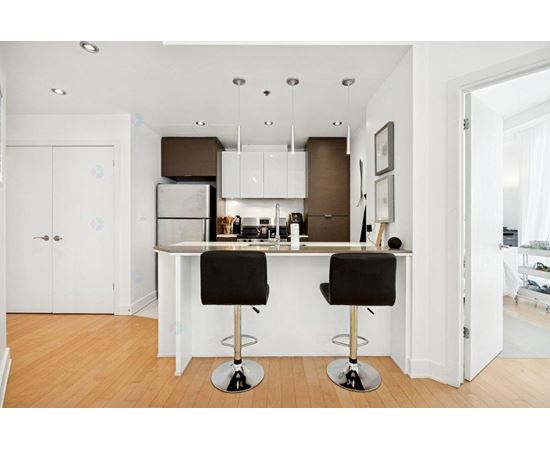 A kitchen with a white counter and black barstools.