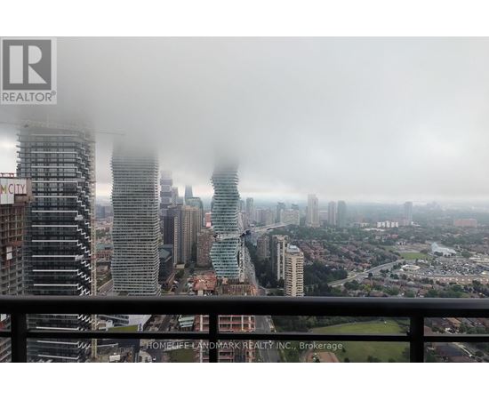 A cityscape with buildings of various heights and a hazy sky.