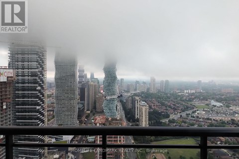 A cityscape with buildings of various heights and a hazy sky.