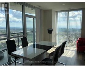 A dining room with a glass table and chairs with a view of the city.