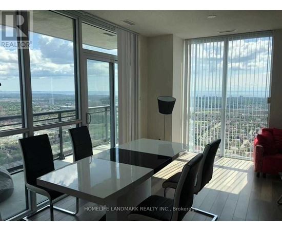 A dining room with a glass table and chairs with a view of the city.