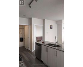 A kitchen with a sink and a fridge.