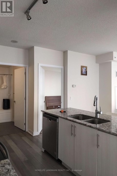 A kitchen with a sink and a fridge.